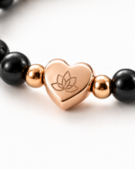 Close up of rose gold lotus heart charm on Obsidian Protection Bracelet