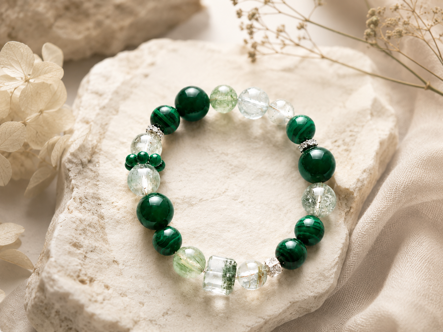 Cancer zodiac bracelet with deep green malachite-style beads, clear crystal accents, silver spacers, and a transparent centerpiece on natural stone