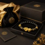 Black obsidian Pixiu bracelet displayed in black and gold gift packaging