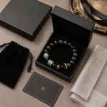 Black obsidian and tiger eye strength and protection bracelet displayed in premium black gift packaging