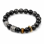 Black obsidian and tiger eye strength and protection bracelet with engraved silver-tone spacers on white background