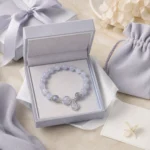 Celestial blue planet charm bracelet displayed in a lavender jewelry gift box with matching pouch