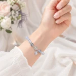 Celestial blue bead bracelet with silver planet charm worn on a woman's wrist