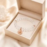 Clear quartz clarity and focus bracelet with rose gold star charm displayed in open cream gift box
