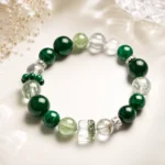 Emerald green mixed crystal bracelet with malachite style beads and clear green crystal accents in a soft elegant product scene