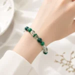 Emerald green mixed crystal bead bracelet worn on a woman's wrist