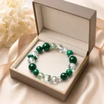 Emerald green mixed crystal bracelet displayed in an open beige jewelry gift box
