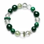Emerald green mixed crystal bead bracelet with malachite style beads and clear green crystal accents on a white background