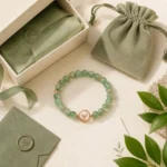 Green aventurine growth and renewal bracelet with green gift box pouch envelope and leaf card flatlay packaging