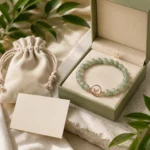 Green aventurine growth and renewal bracelet displayed in green gift box with pouch and natural leaves