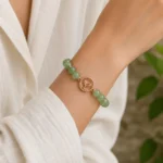 Green aventurine growth and renewal bracelet with rose gold leaf charm worn on wrist