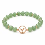 Green aventurine growth and renewal bracelet with rose gold leaf charm on white background