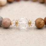 Close-up of mixed jasper grounding and balance bracelet with clear faceted crystal centerpiece