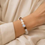 Mixed stone wood and crystal bead bracelet worn on a wrist with neutral satin styling