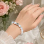 Moonstone square crystal bracelet worn on wrist in elegant soft floral setting