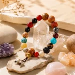 Multicolor gemstone and natural seed bead bracelet displayed with clear quartz and colorful crystal clusters