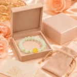 Pale green gemstone lotus bracelet displayed in a peach gift box with velvet pouch and lotus meaning card
