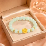 Pale green gemstone lotus bracelet displayed in an open peach jewelry gift box
