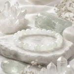 Pale green and white stone bead bracelet displayed with clear quartz crystals and natural stones