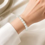 Pale green and white stone bead bracelet worn on a woman's wrist