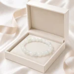 Pale green and white stone bead bracelet displayed in an open ivory jewelry gift box