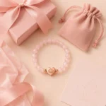 Rose quartz love and self-acceptance bracelet with pink gift box pouch and lotus card flatlay packaging