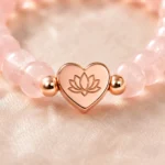 Close-up of rose quartz love and self-acceptance bracelet with rose gold heart lotus charm