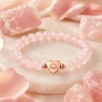 Rose quartz love and self-acceptance bracelet with heart lotus charm styled with raw rose quartz crystals