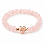 Rose quartz love and self-acceptance bracelet with heart lotus charm on white background