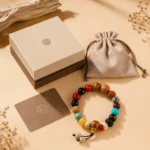 Multicolor feng shui bead bracelet with gift box, jewelry pouch and branded card on a warm beige background