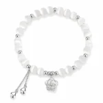 White cat eye bead bracelet with silver rose charm and heart tassel chains on a white background