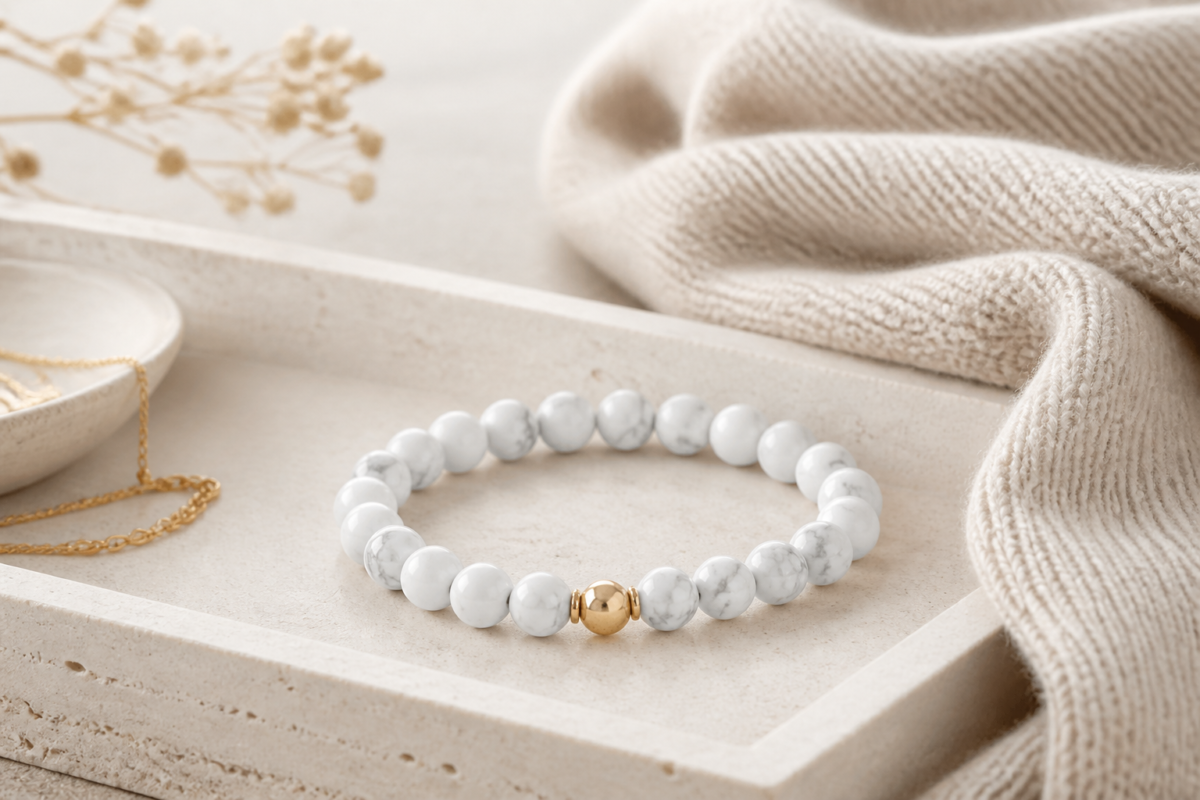 White howlite bead bracelet on a pale stone tray with beige knit fabric