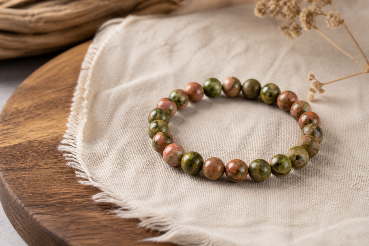 Natural unakite green and salmon bead bracelet on raw linen and warm wood