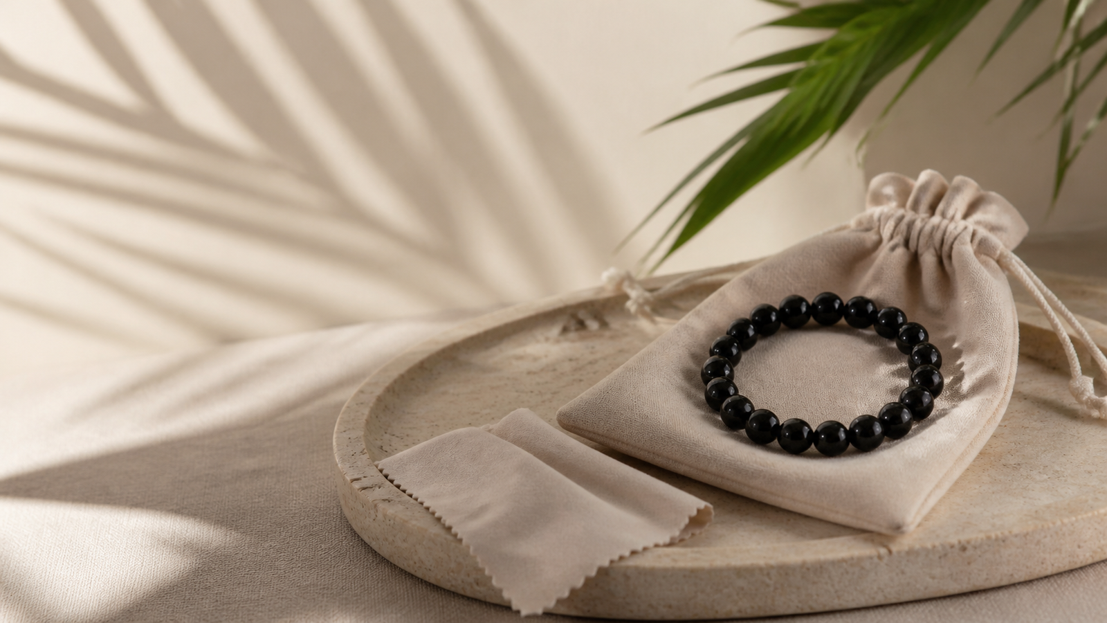 Black crystal bead bracelet beside a jewellery pouch and care cloth