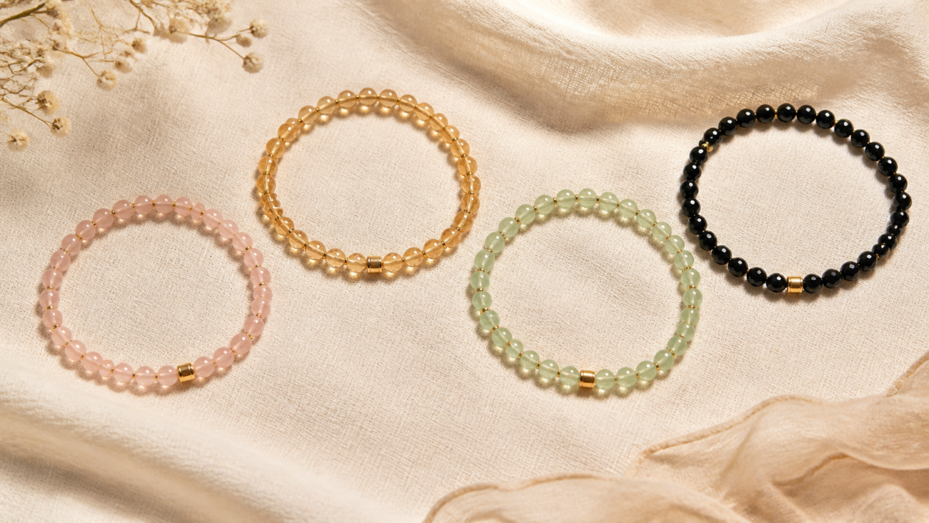 Pink gold green and black crystal bead bracelets on cream linen