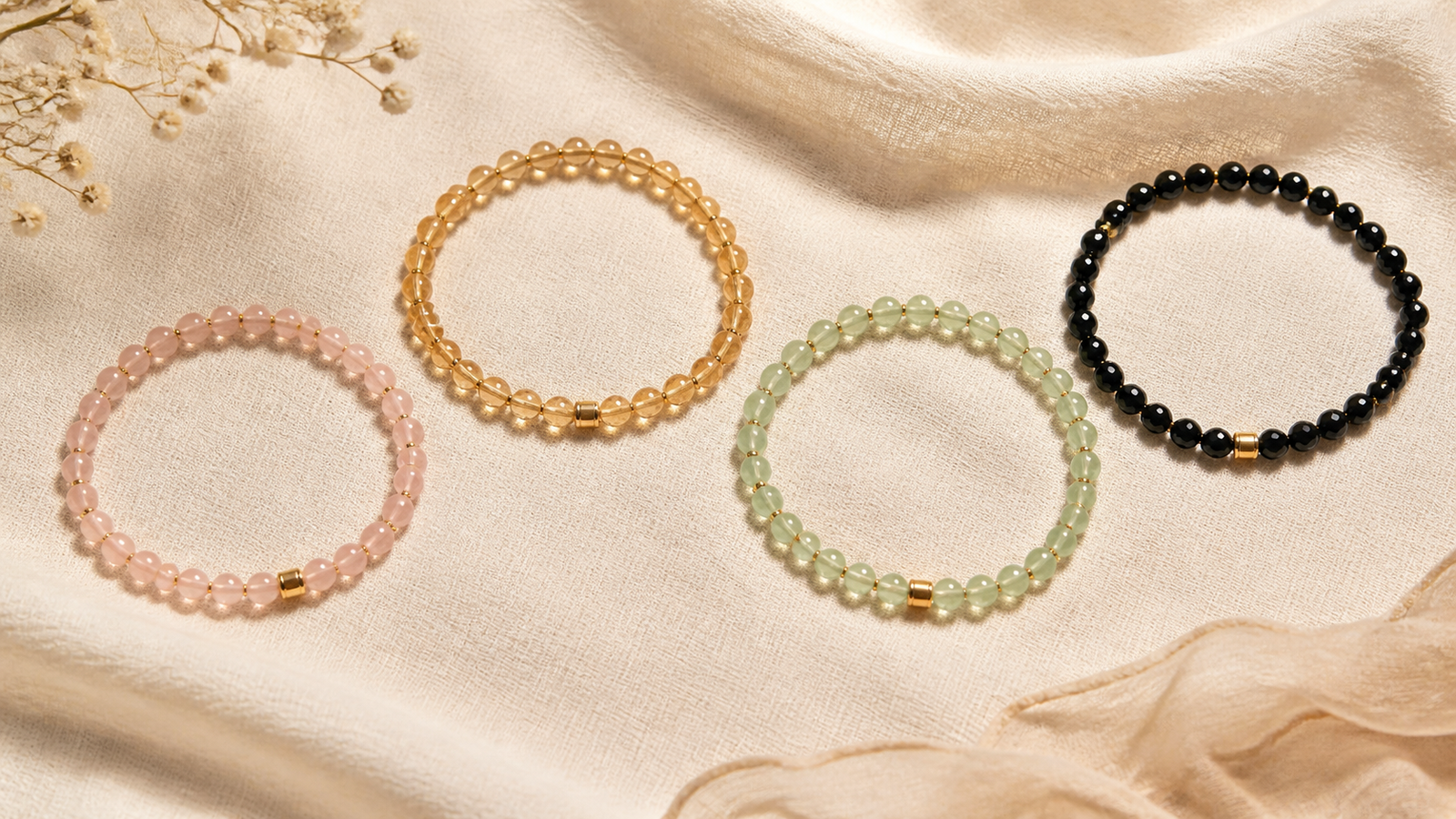 Pink gold green and black crystal bead bracelets on cream linen