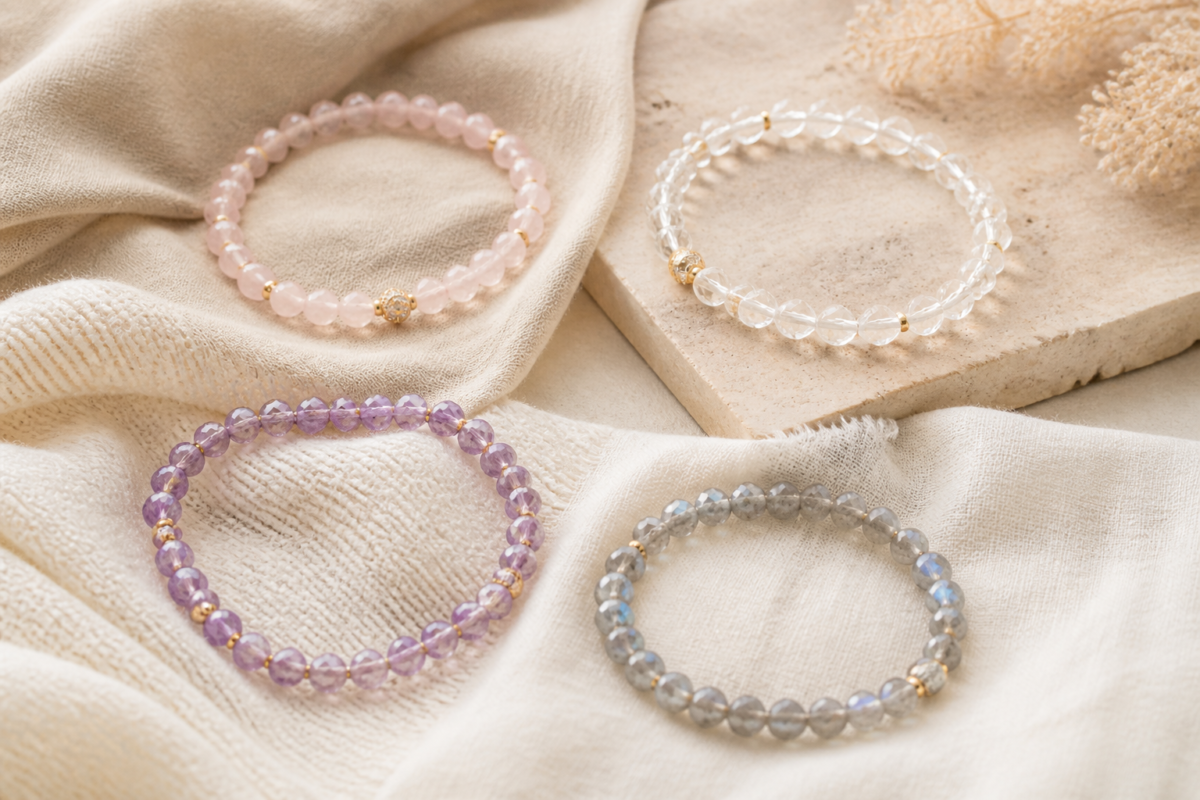 Four crystal bracelets on a neutral wardrobe fabric palette