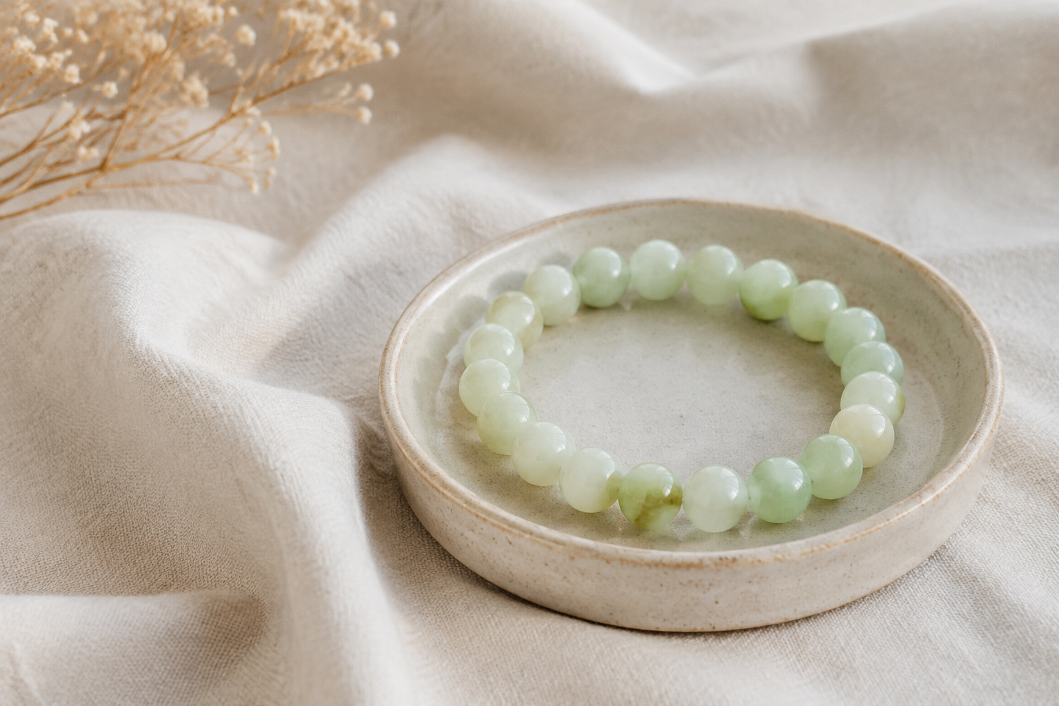 Pistachio calcite pale green bead bracelet on natural linen with a small ceramic tray